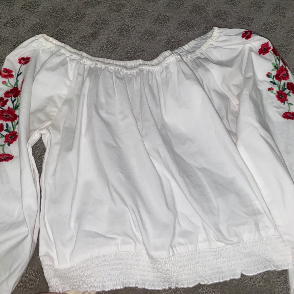 A white off the shoulder blouse with roses